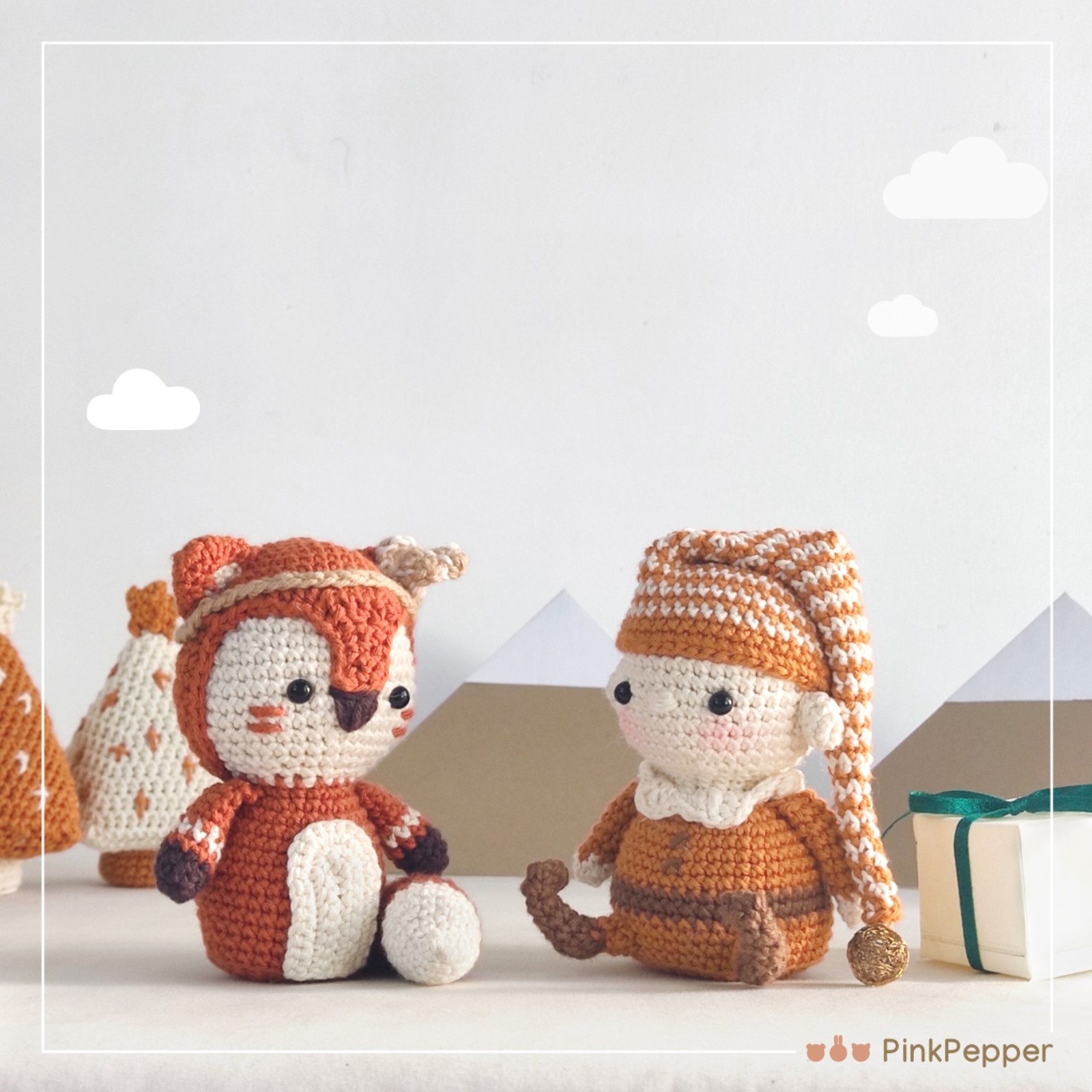 Crochet Cat and Crochet elf in front of paper mountains